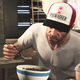 Trevor from GTA V eats a bowl of food with a fork.